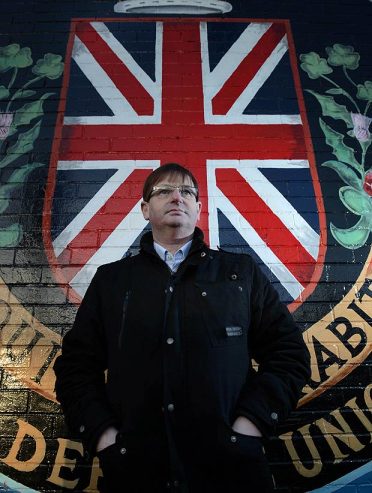 Anti-democracy protest leader and British Unionist militant Willie Frazer poses in front of a British terrorist wall mural, Belfast, Ireland