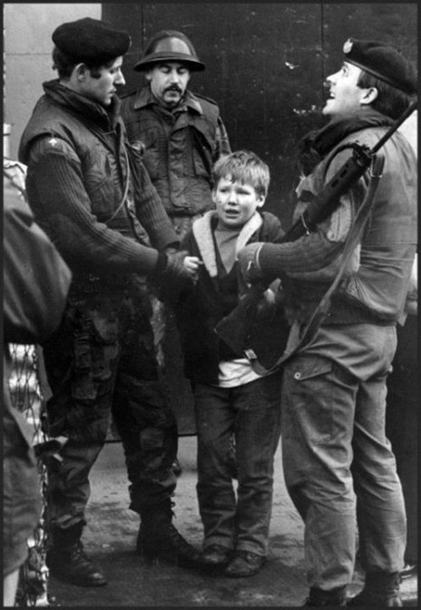 A terrified Irish boy is interrogated by soldiers of the British Army's Gloucestershire Regiment, West Belfast, Ireland, March 1972