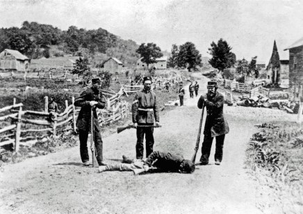 British militiamen stand over the body of a slain soldier of the Irish Republican Army following the Battle of Eccles Hill, the Second Fenian Invasion of Canada 1870