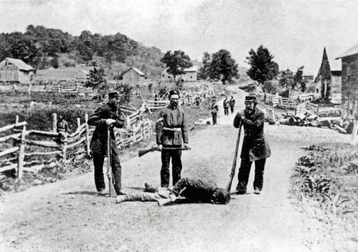 British militiamen stand over the body of a slain soldier of the Irish Republican Army following the Battle of Eccles Hill, the Second Fenian Invasion of Canada 1870